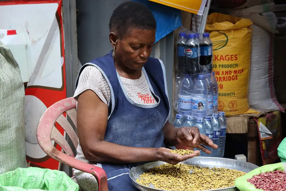 A woman sorting beans at her produce and seed stall